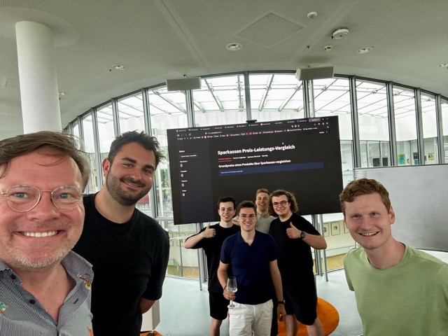 The team in front of a screen showing a tool they built together